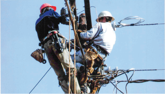 In Sudan, Tyler, right, helped teach local men how to install electric infrastructure